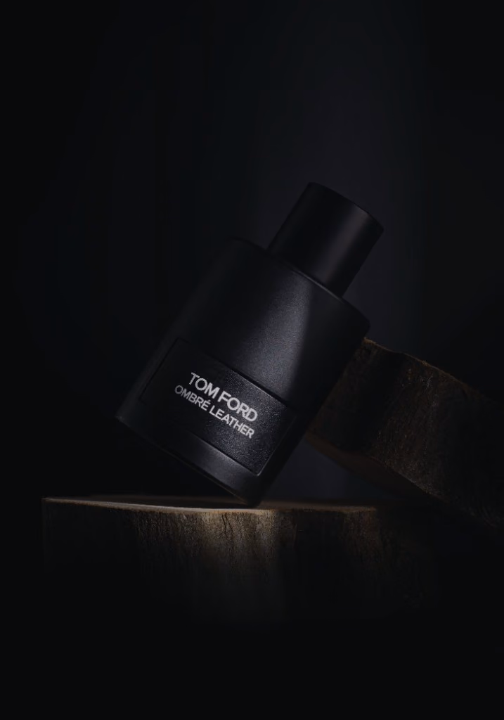 Tom Ford Ombré Leather leaning on a cut log in the dark